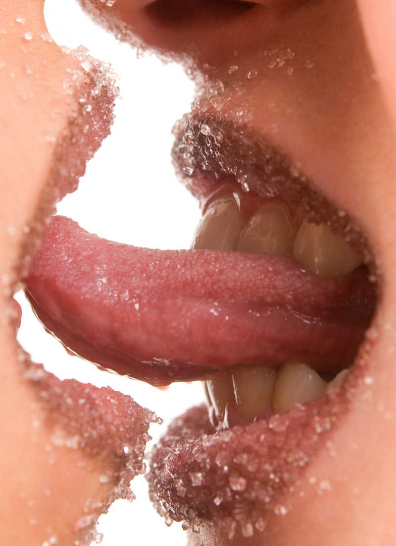 两个女孩的嘴唇沾满了糖颗粒亲吻特写