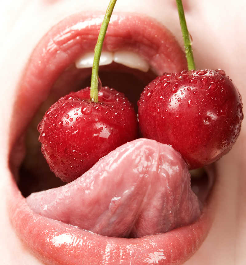 年轻的女人吃红樱桃特写