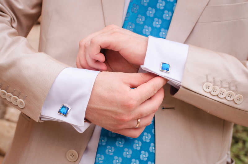 新郎的胳膊固定他的蓝色袖口特写