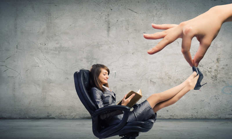 年轻漂亮的女人在椅子上看书