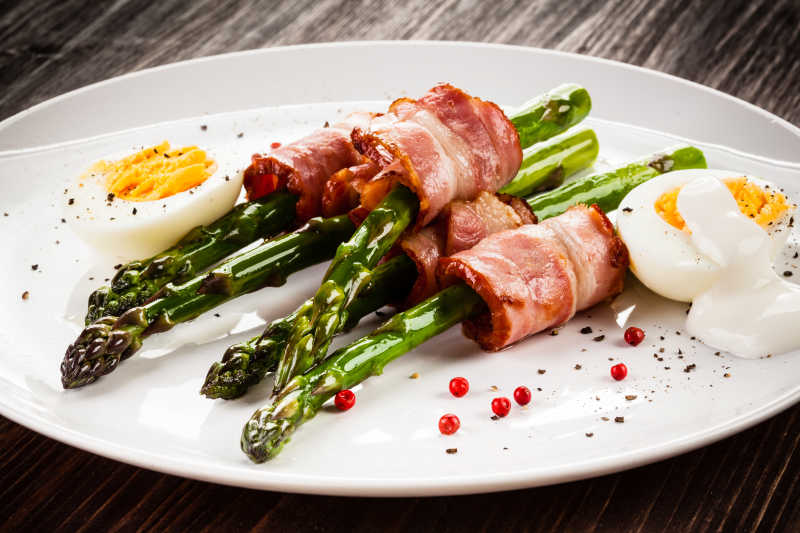 白色盘子中的芦笋炒咸肉和煮鸡蛋