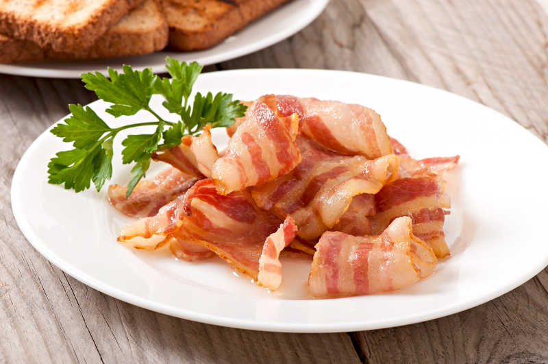 白色盘子上的油炸培根