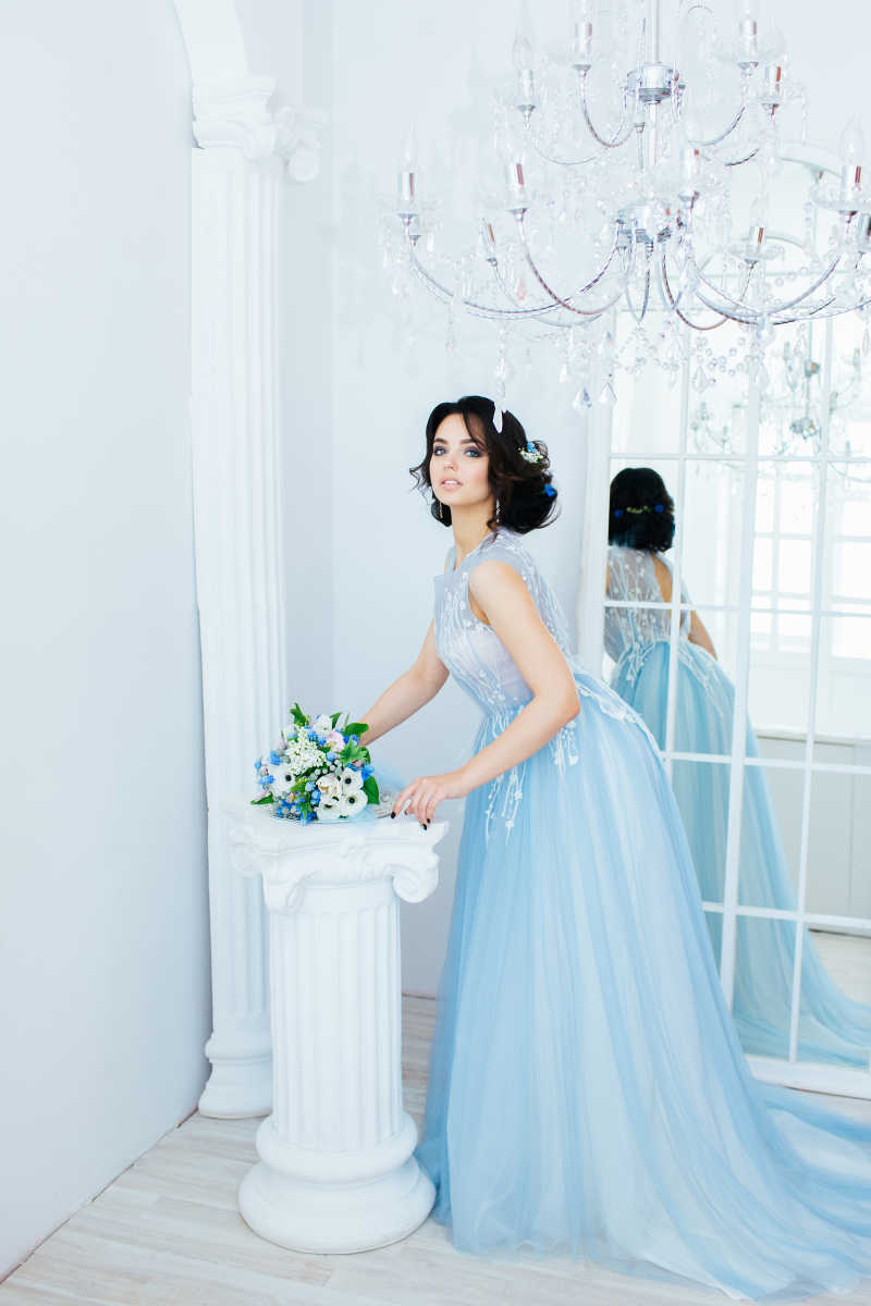 身穿蓝色婚纱注视前方的女人