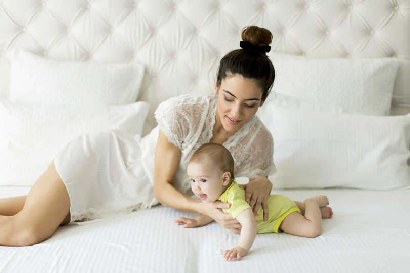 年轻的母亲正微笑望着宝宝