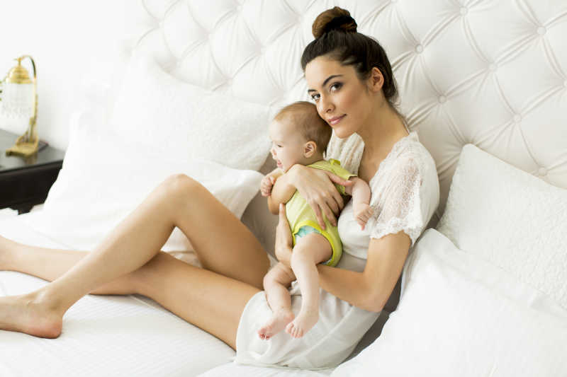 年轻的母亲抱着孩子玩耍