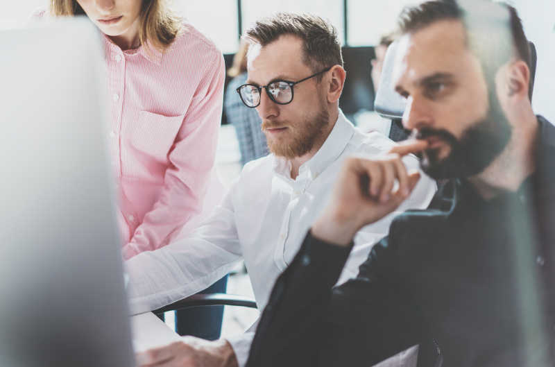 认真看着电脑的三个白领人士