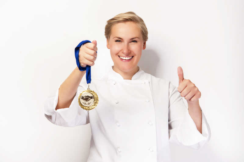 女厨师手拿奖牌并伸出大拇指