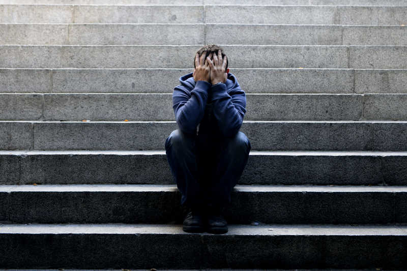 年轻的男子坐在楼梯上