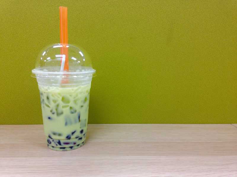 木质桌子上的冰奶绿茶