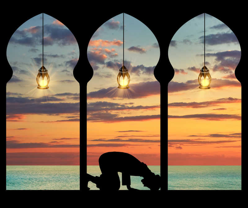 海上落日背景下祈祷的穆斯林