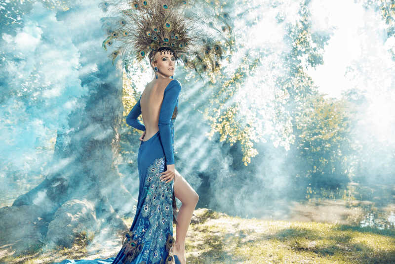 穿着华丽的年轻女人在森林中摆姿势