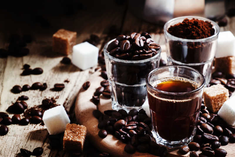三个杯子装着咖啡豆咖啡粉末和咖啡