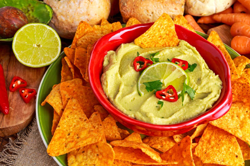 桌子上的牛油果泥和薯片