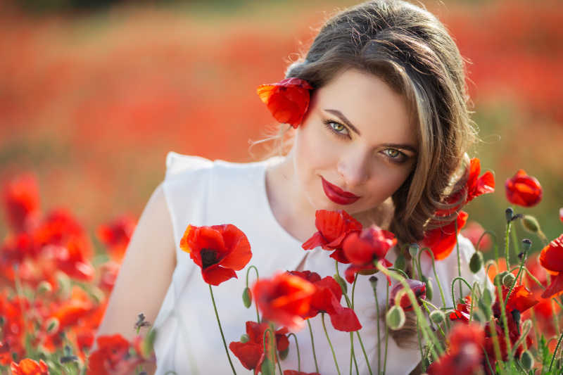 罂粟花丛中低着头的美女