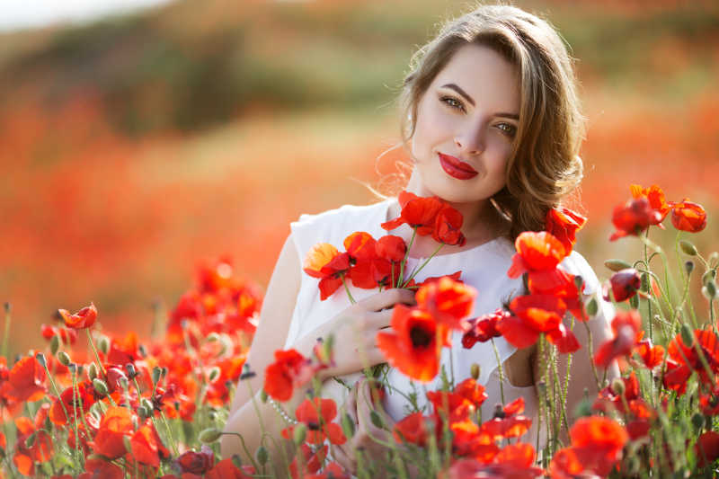 罂粟花丛中的美女微笑着