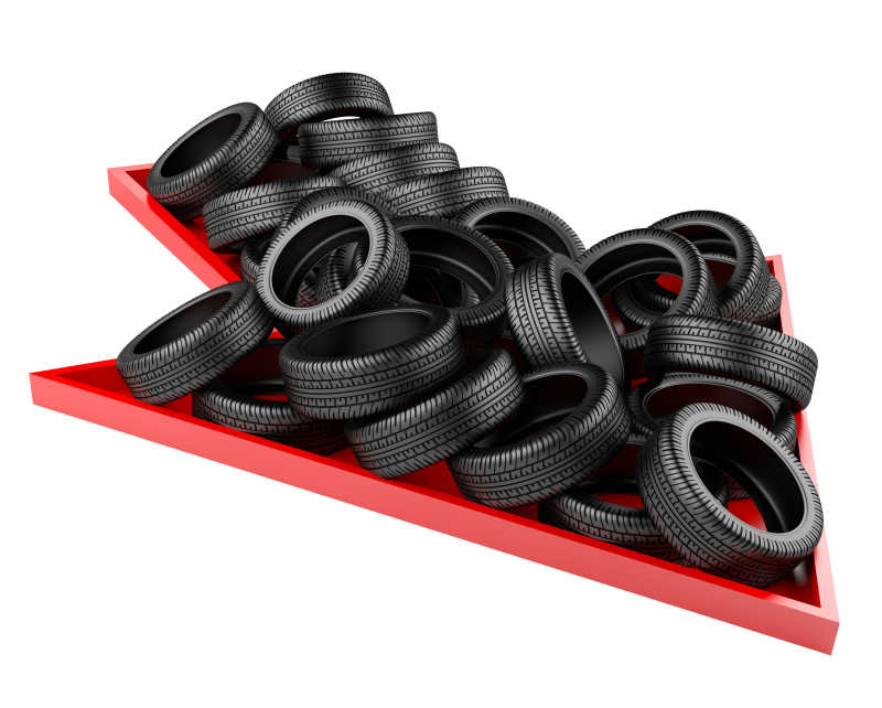 堆积在红色箭头上的轮胎