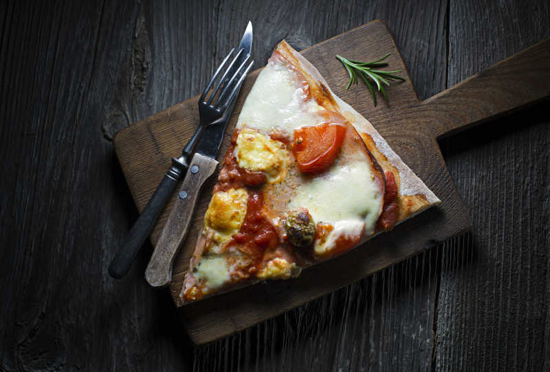 桌上放着一块奶酪芝士披萨