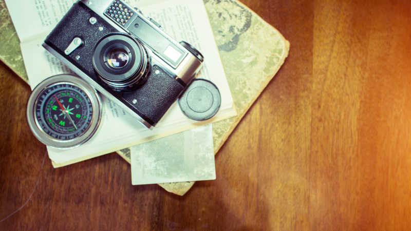 木制桌子上的相机与照片