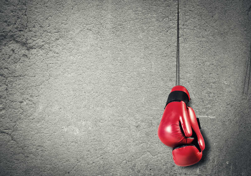 灰色墙上挂着红色拳击手套