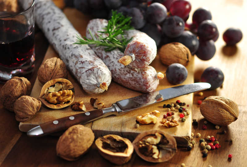 砧板上放有香肠核桃与葡萄