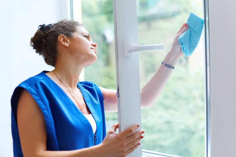 漂亮的女人在清洗窗户