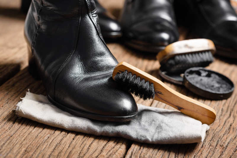 用刷子清洁黑色皮鞋
