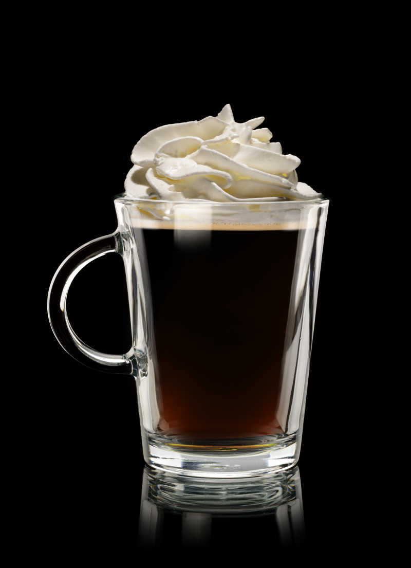 在黑色背景下加奶油的咖啡杯