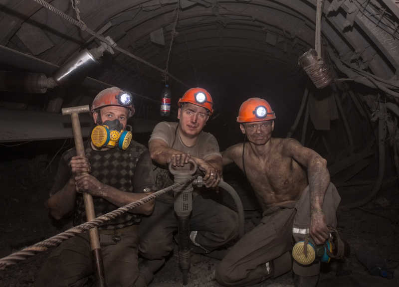 地下工作的矿工拿着工具