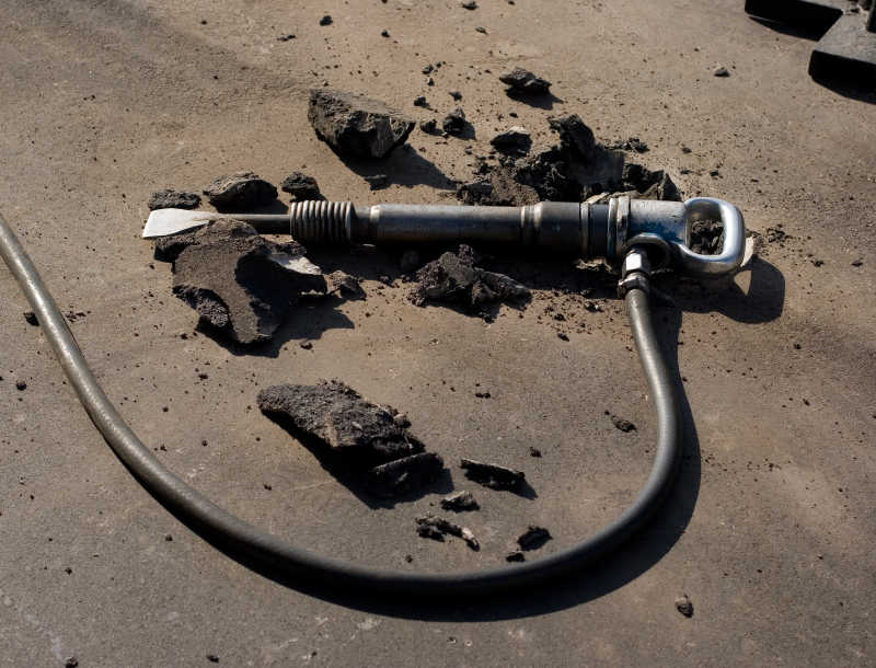 放在破碎沥青路面上的气动镐锤