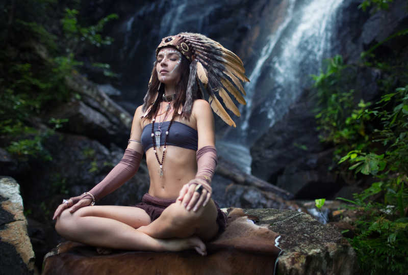 穿着传统服饰的印度妇女在瀑布上沉思