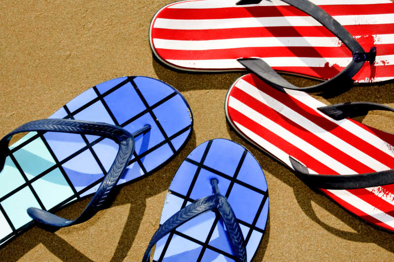 两副拖鞋在沙滩上