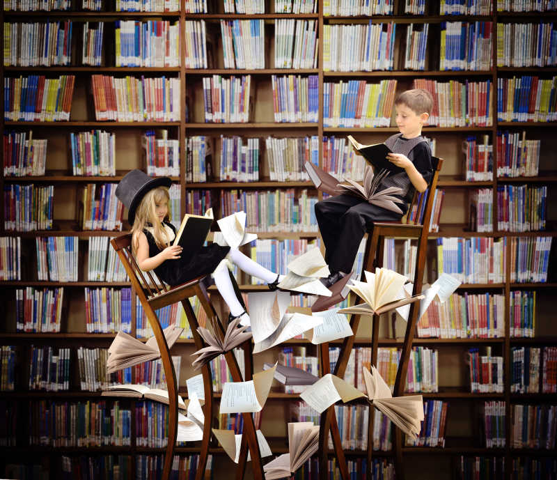 坐在椅子上看书的男孩和女孩