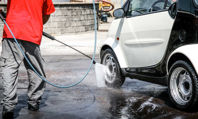 男洗车工用气枪洗车