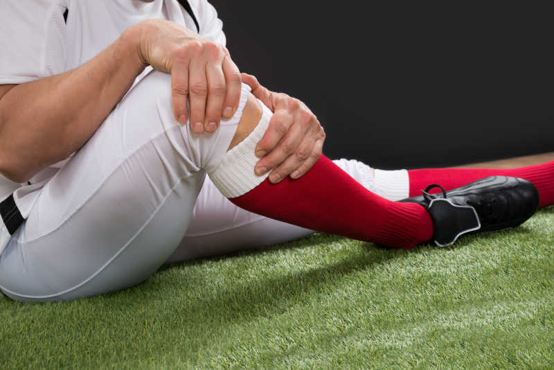 在球场上腿部受伤的美式橄榄球运动员的特写镜头