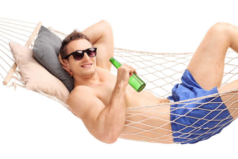 男人躺在吊床上喝啤酒