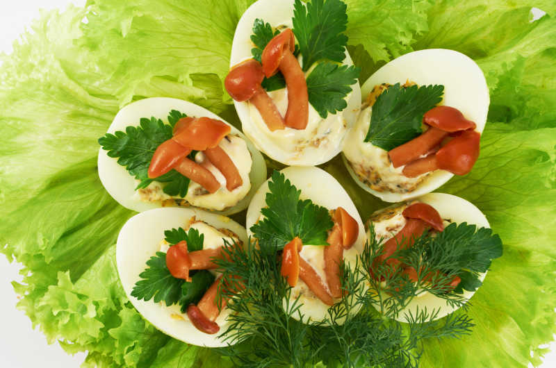 用沙拉蘑菇装饰的煮熟的酿鸡蛋