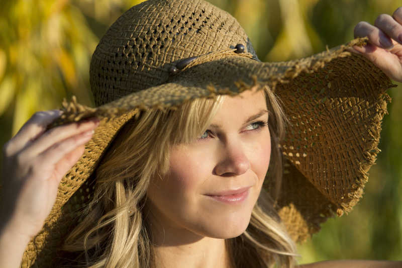 在户外戴着草帽的金发女孩