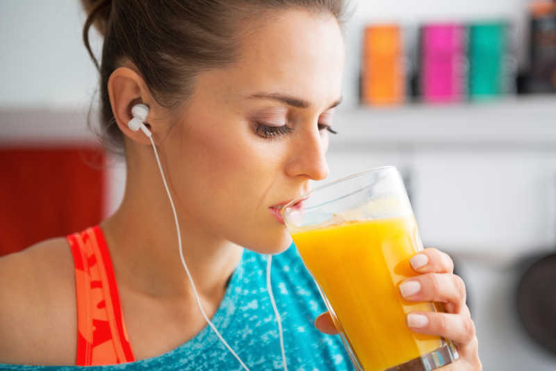 健身的年轻女性在喝南瓜汁