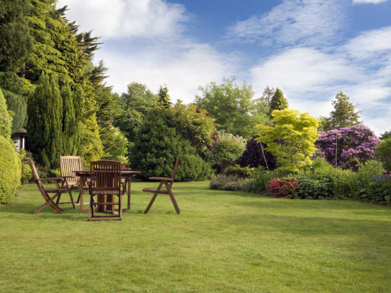 蓝天白云背景下的草地上的餐桌椅