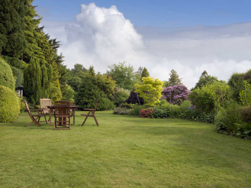 大朵白云背景下草地上的餐桌椅