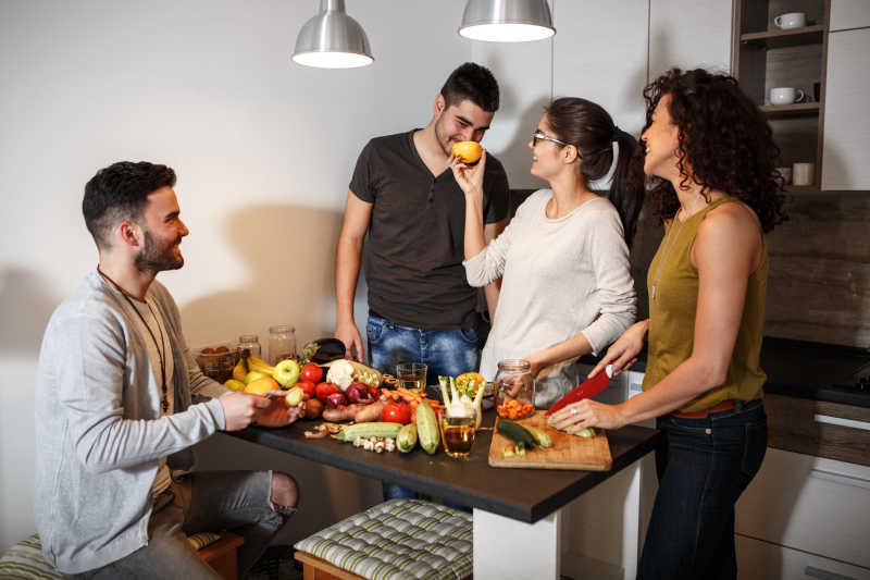 朋友们聚在一起照着笔记本做餐