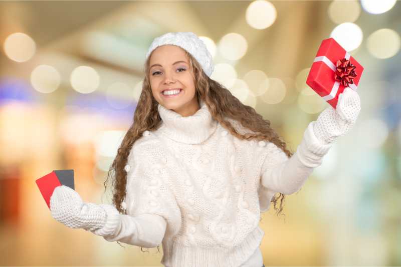 手拿圣诞礼物的女子面带微笑