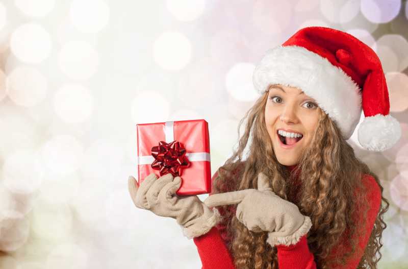 手拿圣诞礼物的女子一脸惊讶