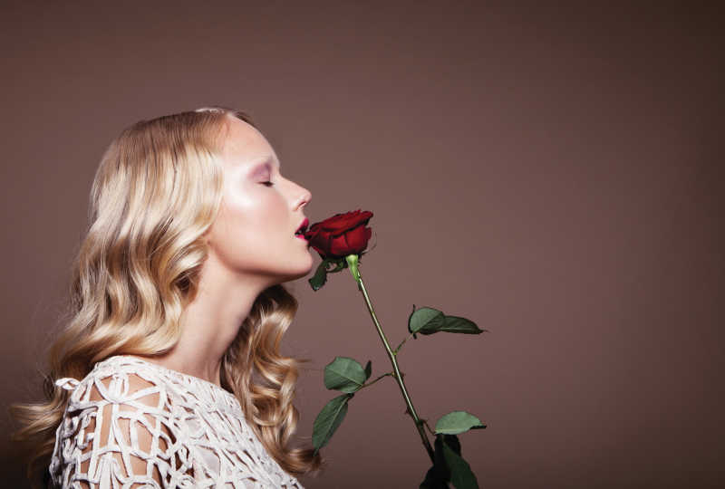 正在亲吻玫瑰的金发美女