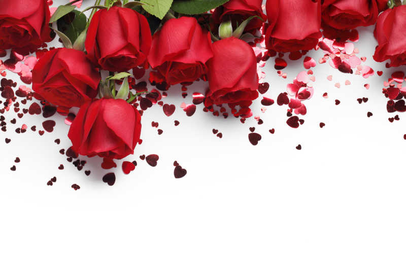白色背景下的红玫瑰和心形饰物