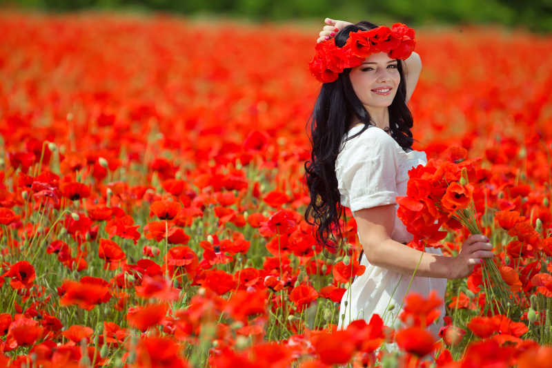 红色花海中戴着花朵的年轻长发女子