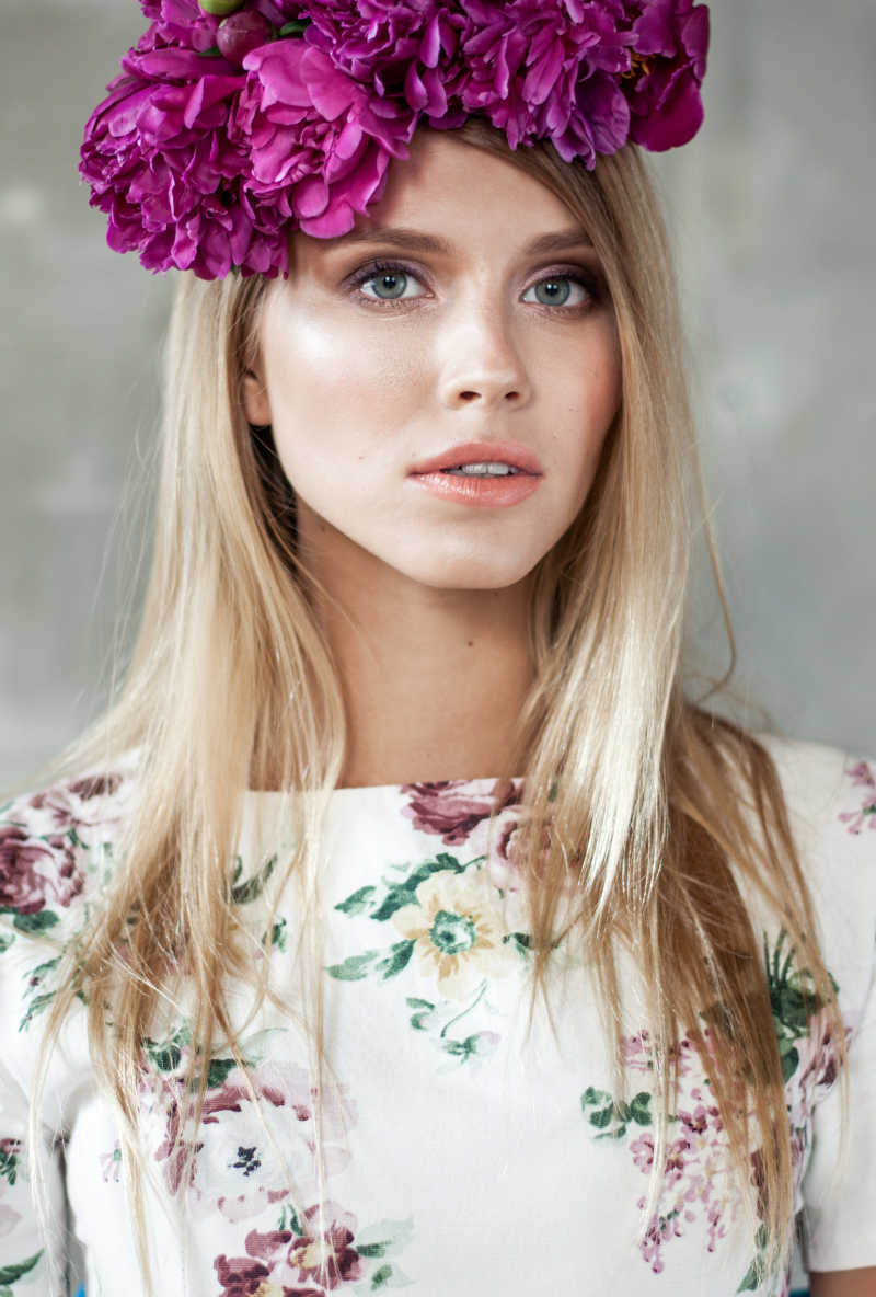 戴着紫色牡丹花朵的年轻金发女子