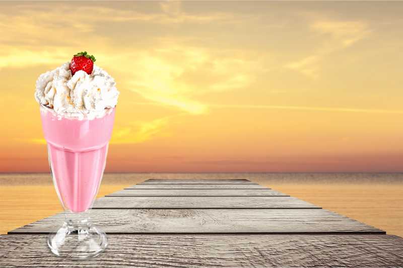 一杯孤立的粉红色的奶昔特写