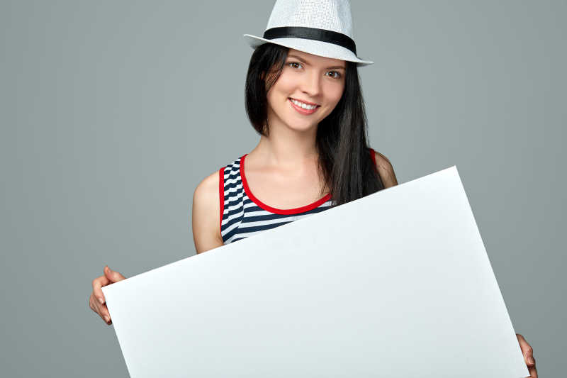 戴帽子的女孩展示空白横幅广告牌