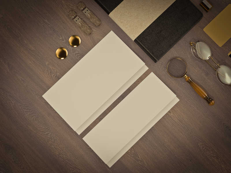 木制背景前的白色纸张放大镜和眼镜